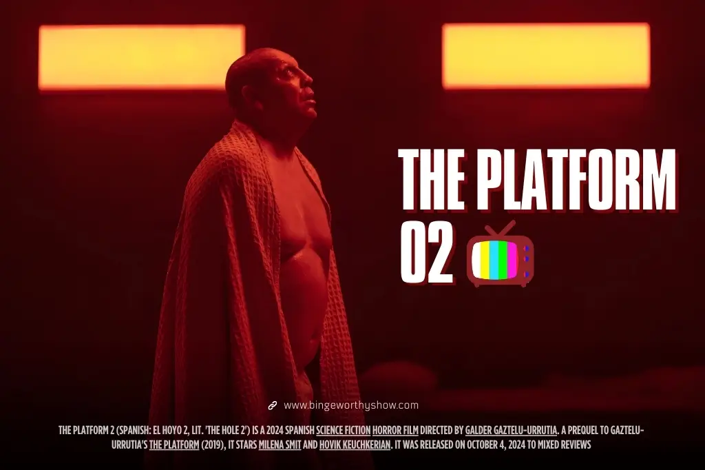 Hovik Keuchkerianm shirtless and wrapped in a blanket looking upward while bathed in red light in The Platform 2